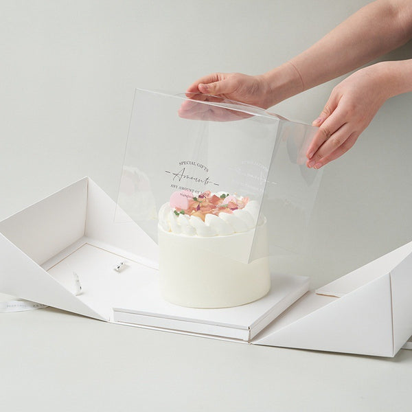 White cake box with cake inside and a ribbon opening